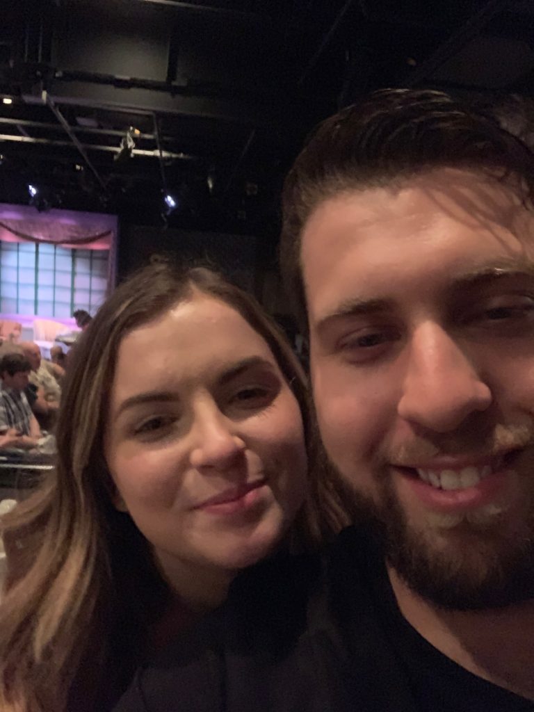 romantic and cute couple smiling on a  special date at a dinner theatre 