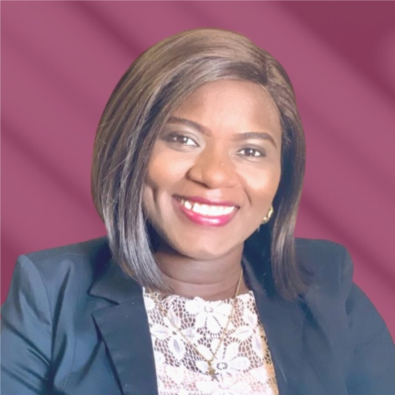 Woman with brown hair dressed formally with a purple background posing for a professional photo.