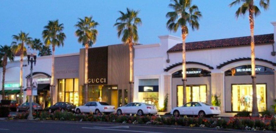 The Gardens on El Paseo in Palm Desert California with luxury shopping and palm trees with a blue sky and cars