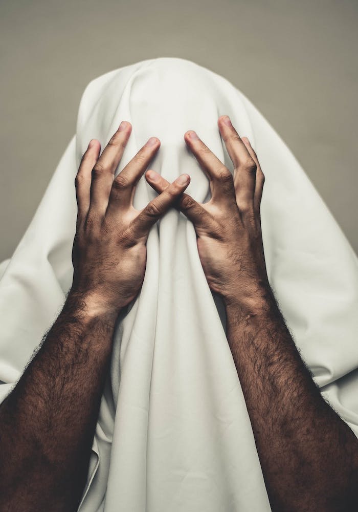 person with schizophrenia holds blanket over face